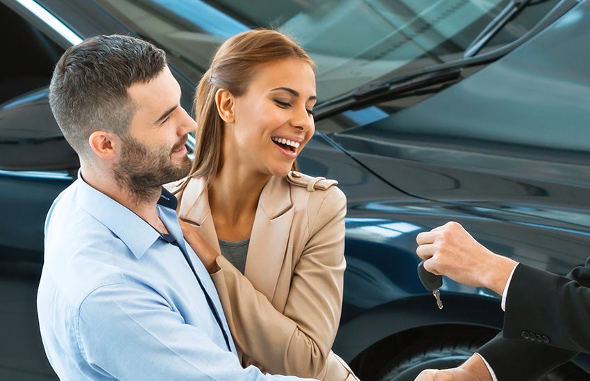 customers happy they bought a vehicle at Dan Cummins Chevrolet Buick of Paris dealership as the sales manager hands them their keys